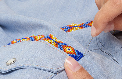 Sewing beaded strips onto a shirt pocket